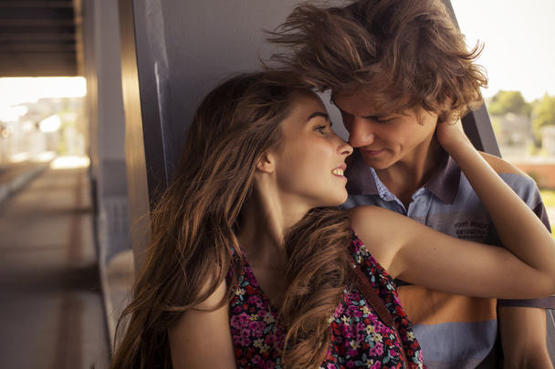 橋塔に夏の夏時間で抱き締める若いカップル - 写真・画像
