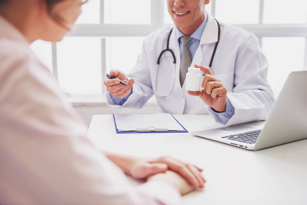 Обрезанный образ красивого врача, предлагающего лекарства женщине после консультации
 - Фото, изображение