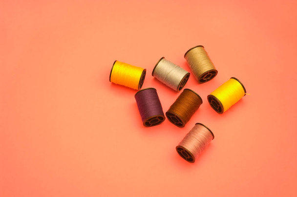 Kabels van garen van verschillende kleuren om kleding te naaien en verschillende arrangementen van kalmte te maken. - Foto, afbeelding