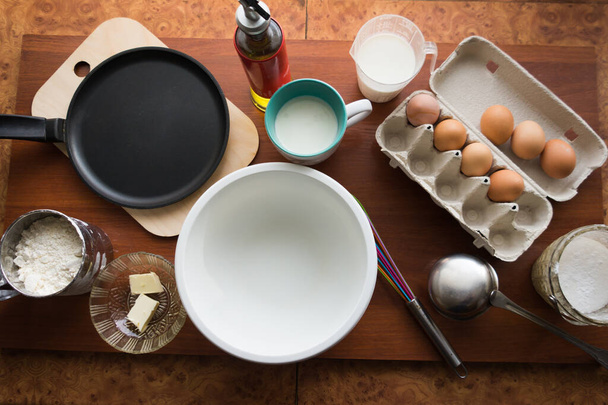 Pannenkoekenweek. Bereiding van het deeg voor het bakken van heerlijke en roodbruine pannenkoeken van de ingrediënten eieren, bloem, boter en melk. Maslenitsa traditionele Russische festival maaltijd. - Foto, afbeelding