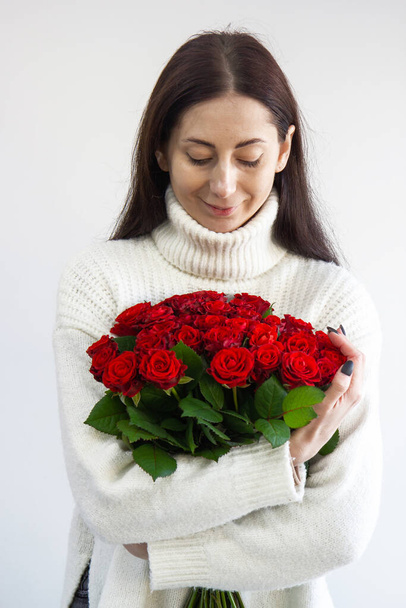 lány kezében egy csokor vörös rózsa - Fotó, kép