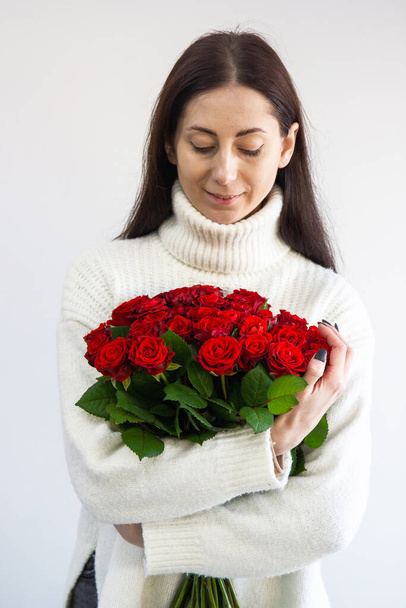 Mädchen mit einem Strauß roter Rosen - Foto, Bild