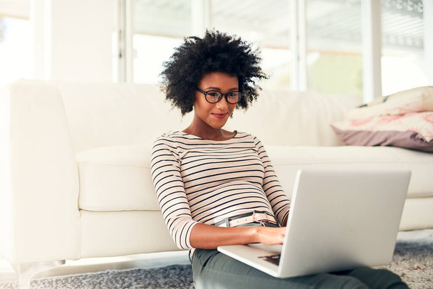 Проводит немного свободного времени в сети. Обрезанный снимок молодой женщины, работающей над своим ноутбуком дома. - Фото, изображение