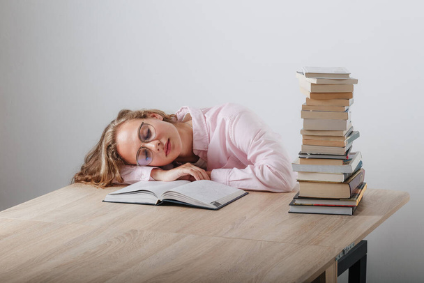 The girl fell asleep at the desk while reading - Fotoğraf, Görsel