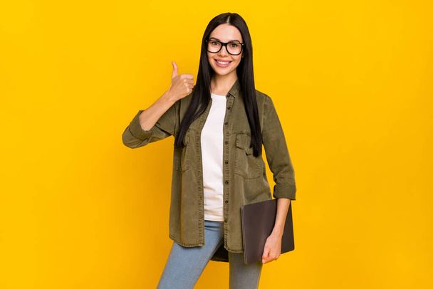 Photo of cool young lady hold laptop thumb up wear spectacles shirt isolated on yellow background - Fotoğraf, Görsel