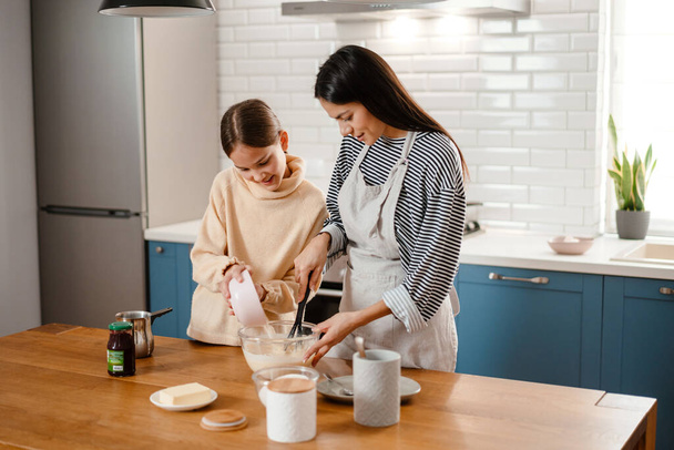 幸せな母親と娘調理朝食一緒にキッチンで - 写真・画像