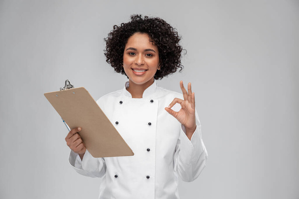 mosolygós női szakács vágólappal - Fotó, kép