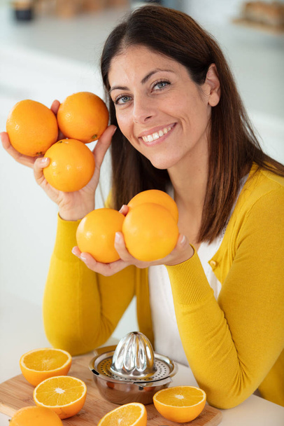 beautiful dark-haired girl holding oranges in her hands - Foto, Imagem