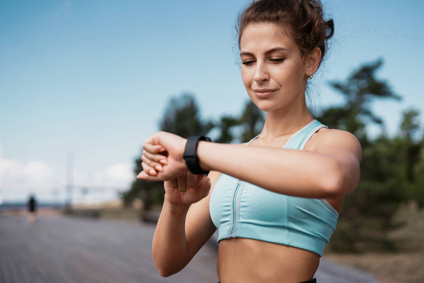 Smart watch heart rate measurement. Health and lifestyle. Portrait of a woman exercising and running. The trainer is a marathon for a distance. Fitness cardio workout on the street in the city. - Fotoğraf, Görsel