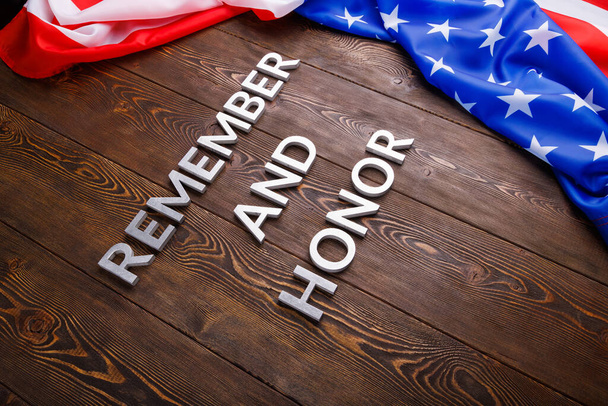 Kelimeler unutmayın ve onurlandırın gümüş metal harflerle ahşap arka planda ABD bayrağı sağ tarafta - Fotoğraf, Görsel