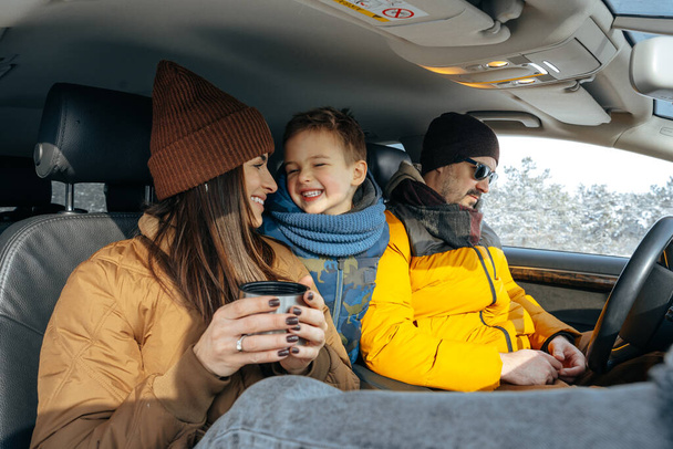 Mother, father and child traveling by car on a vacation to the mountains in winter - Foto, Bild