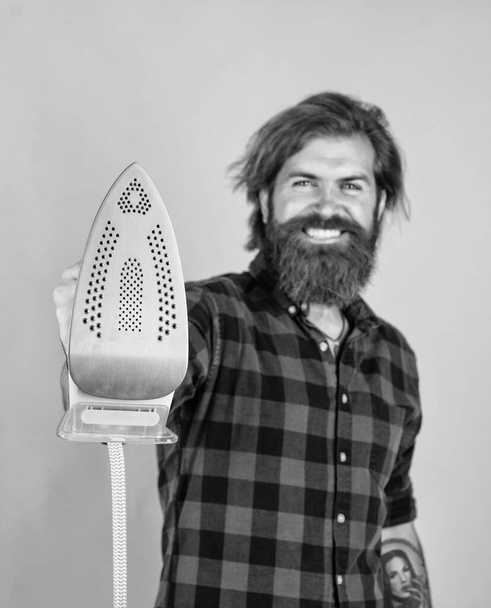 so hot. bearded man. new technology. mature hipster with beard use steaming iron. brutal caucasian hipster with moustache ironing. male housekeeper. happy shop assistant in checkered shirt - Photo, Image