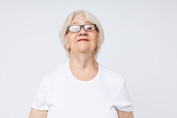 emotional elderly woman vision problems with glasses light background - Zdjęcie, obraz