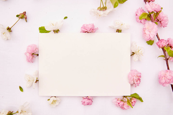 Naisellinen paperi kortti mockup keväällä valkoinen ja vaaleanpunainen herkkä kukkia. Romanttinen, häät, syntymäpäivä, kutsu, äitienpäivä mallintaa kortin käsite. Kopioi tilaa. Yläkuva. - Valokuva, kuva