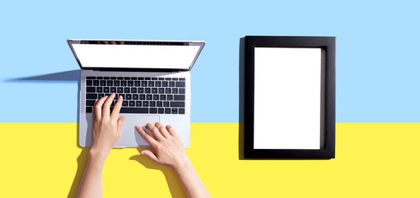 Laptop computer with a blank photo frame - 写真・画像