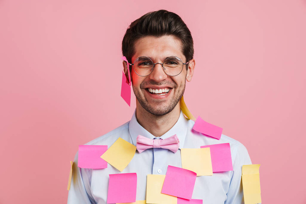Young white man with stickers laughing and looking at camera isolated over pink background - Photo, image