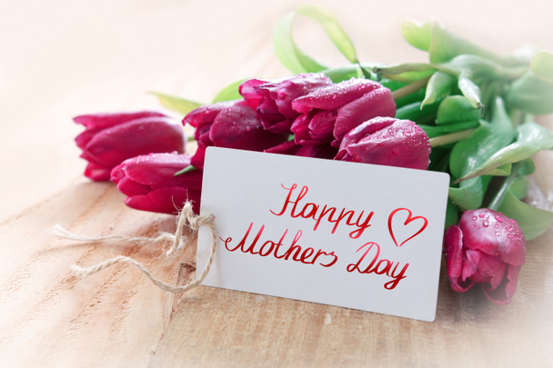 Karta Happy Matki Day z fioletowymi tulipanami na tle drewna. - Zdjęcie, obraz