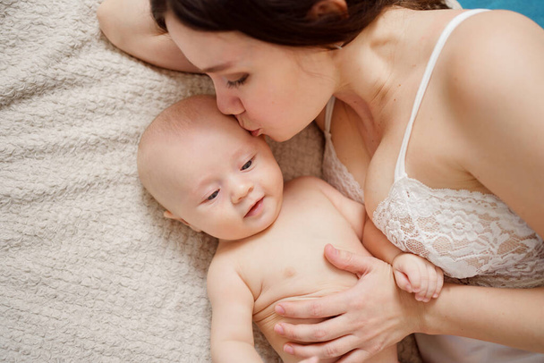 a mother and the baby on the bed. maternal and child health.  - Foto, Bild