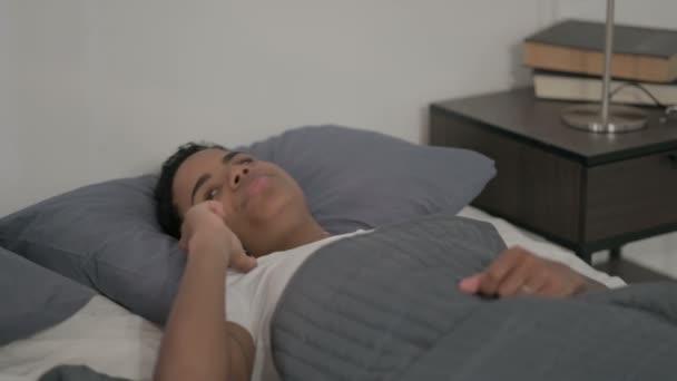Donna africana che parla su smartphone mentre dorme a letto - Filmati, video