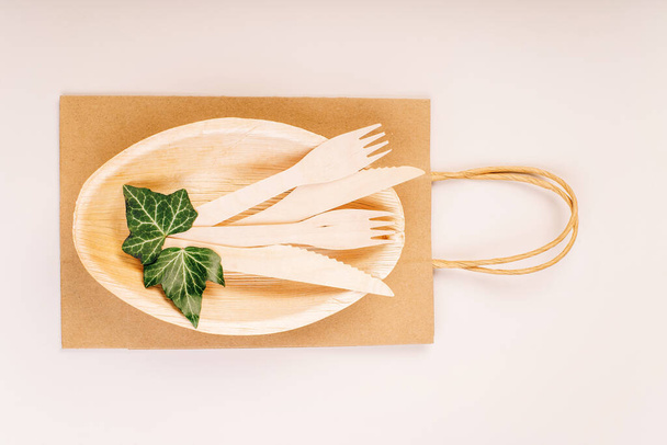 Eco craft paper tableware,cups,fast food containers.Recycling,eco-friendly concept.Disposable eco cutlery,plates,spoons,knives,forks on a light background.Craft paper bag for food delivery.Copy space. - Foto, Imagen