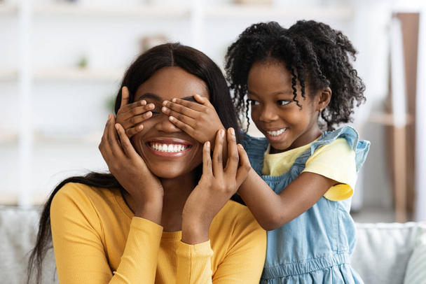 Muotokuva pieni musta tyttö pelaa Arvaa kuka peli hänen äitinsä kanssa - Valokuva, kuva