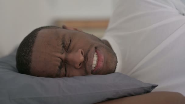 Primer plano del hombre africano con dolor de cabeza mientras duerme en la cama - Imágenes, Vídeo