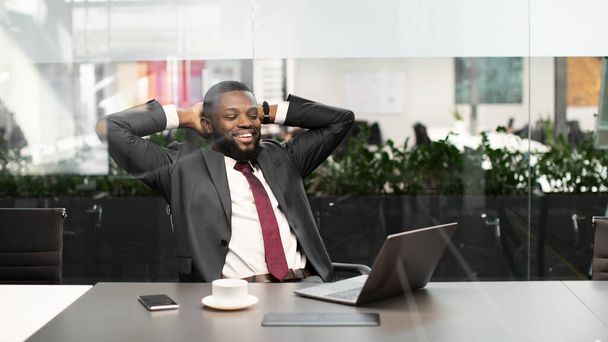Sukces afrykańskiego menadżera siedzącego przed notebookiem - Zdjęcie, obraz