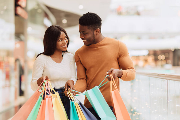 heureux noir couple tenant shopping sacs regarder l 'autre - Photo, image