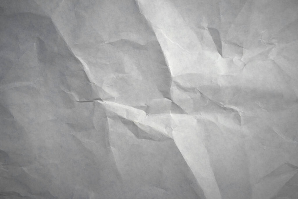 Beyaz buruşmuş bir kağıt parçasının dokusunun fotoğrafı. Buruşmuş parçalarla dolu temiz bir karton yaprak.. - Fotoğraf, Görsel