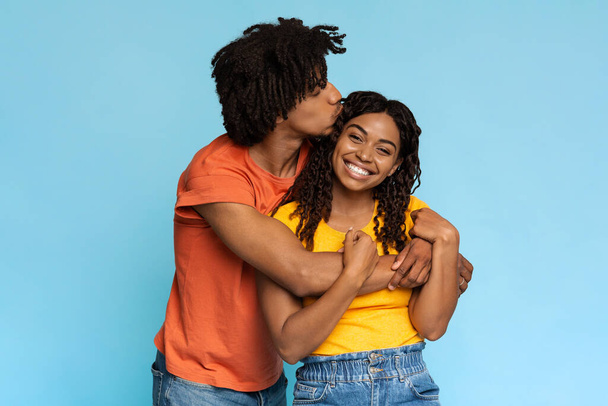 Loving black guy kissing his happy girlfriend - Foto, afbeelding