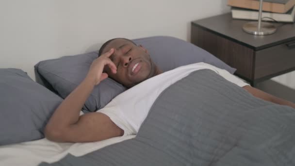 Hombre africano con dolor de cabeza mientras duerme en la cama - Imágenes, Vídeo