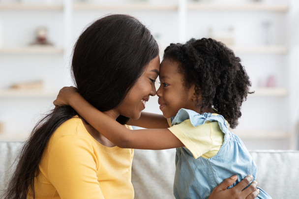 Kochająca Rodzina. Cute Little Black Girl i jej matka Obejmuje w domu - Zdjęcie, obraz