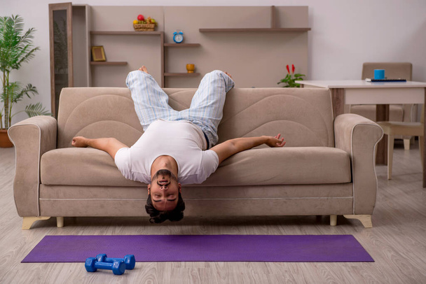 Jeune homme faisant des exercices sportifs à la maison - Photo, image