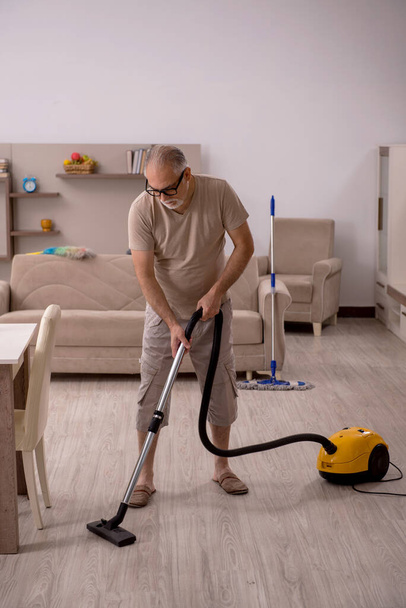 Vecchio che fa i lavori domestici a casa - Foto, immagini