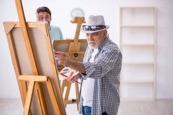 Δύο άνδρες ζωγράφοι απολαμβάνουν ζωγραφική στο σπίτι - Φωτογραφία, εικόνα