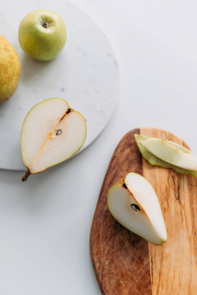Pears and an apple with marble and wooden boards. Top view. - Foto, Bild