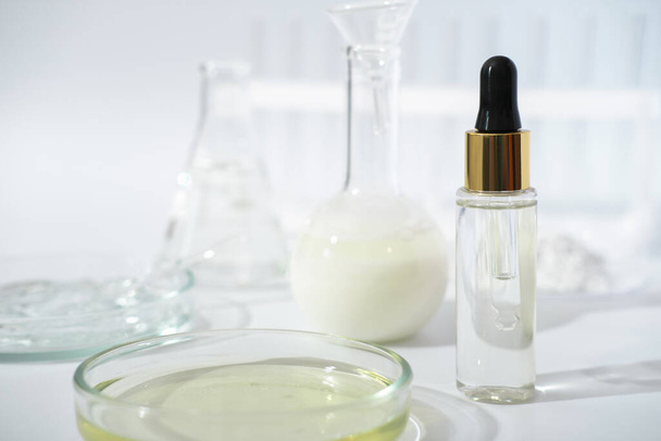 laboratory dishes and glassware on a lab table. fermentation, fermented beauty skin care. dropper bottle of solution or serum for anti age treatment - Photo, Image