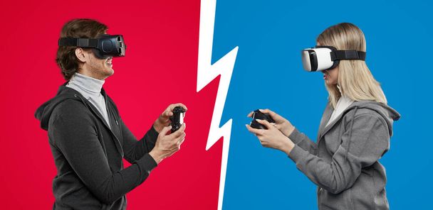 Man and woman in VR goggles playing against each other - Fotó, kép