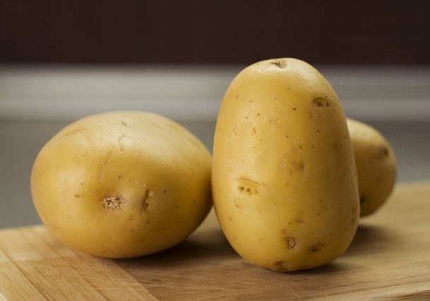 Group of potatoes waiting on breadboard - Photo, image