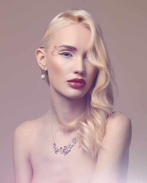 fashion portrait of beautiful blond girl with heart on her face. make-up beauty young woman in jewelry necklace. Valentines day - Photo, Image