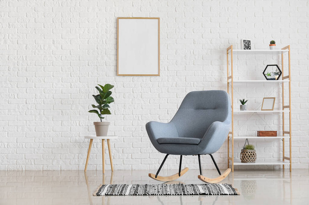 Rocking καρέκλα, houseplant και rack στο μοντέρνο κομψό εσωτερικό του σαλονιού - Φωτογραφία, εικόνα
