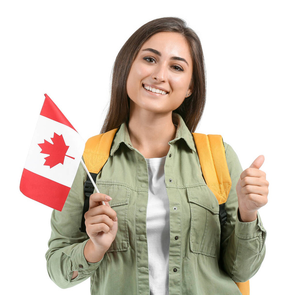 Joven estudiante con bandera nacional de Canadá mostrando gesto de pulgar hacia arriba sobre fondo blanco - Foto, Imagen