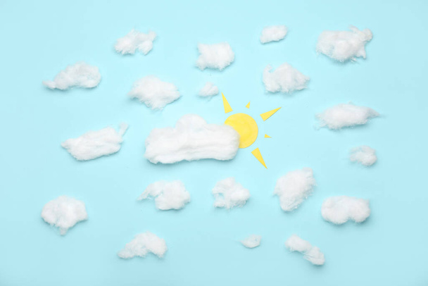 Kreatív kompozíció pamut gyapjú felhők és papír nap színes háttér - Fotó, kép