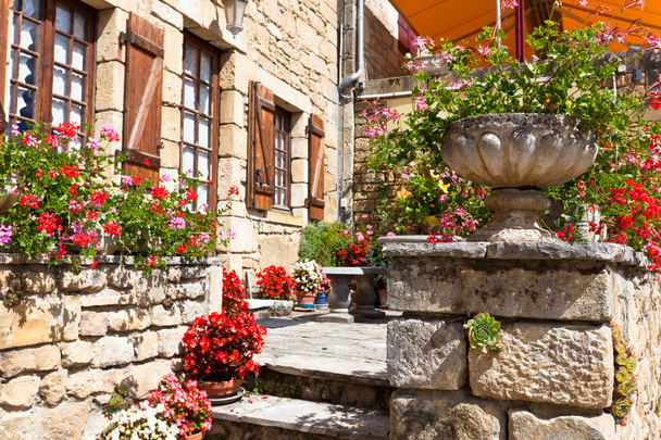 Bright flower pots on an ancient stone house in France - Foto, Bild