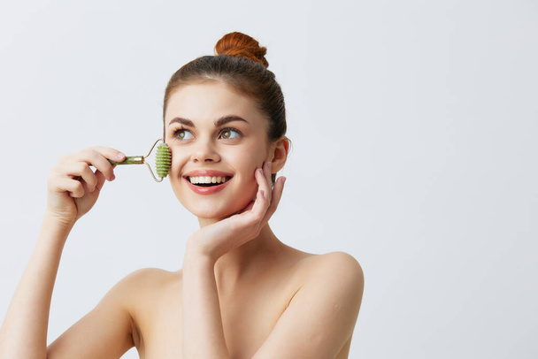 pretty woman with  jade face massager on  isolated background. High quality photo - Photo, Image