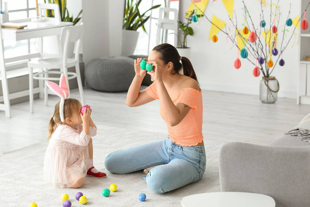 Happy mother and her little daughter having fun with Easter eggs at home - Zdjęcie, obraz