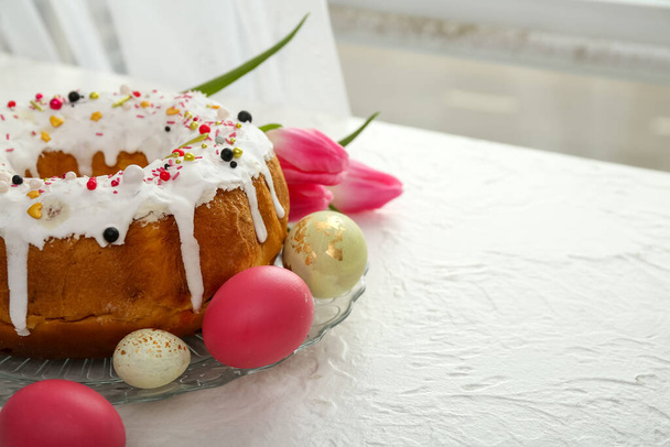 Tányér ízletes húsvéti tortával, tojás és virágok könnyű asztalon - Fotó, kép
