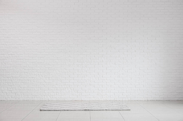 View of white brick wall and carpet in big room - Фото, изображение