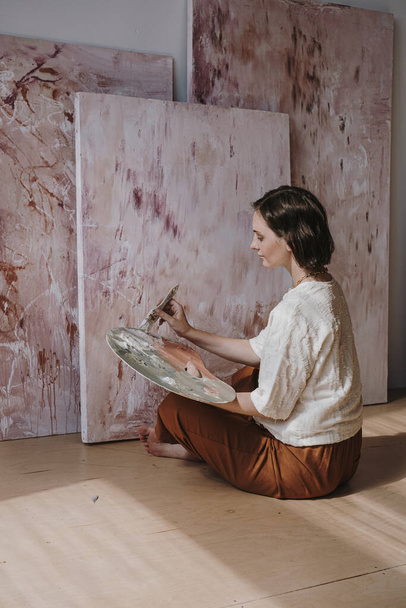 Meisje kunstenaar schilderen abstract beeld in atelier. Esthetisch minimalistisch kunstwerk creatie concept - Foto, afbeelding