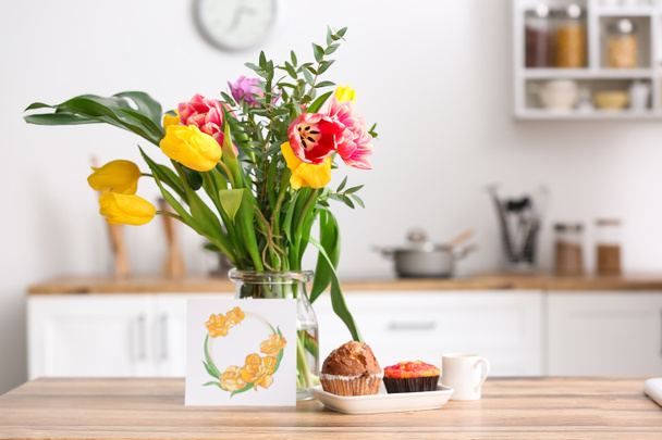 Vase with flowers, breakfast and greeting card on dining table in kitchen - Valokuva, kuva